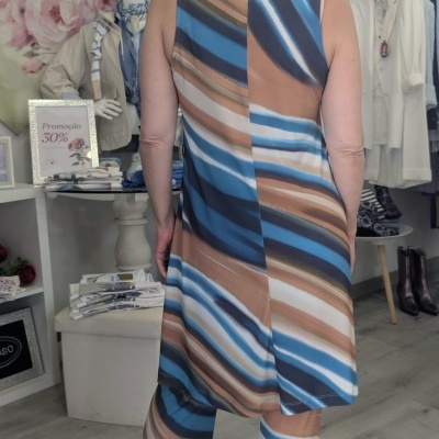 Mulher de costas com conjunto riscado azul e bege em loja de roupa