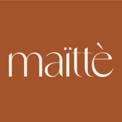 Logótipo branco com a palavra 'maïttè' em fundo castanho alaranjado