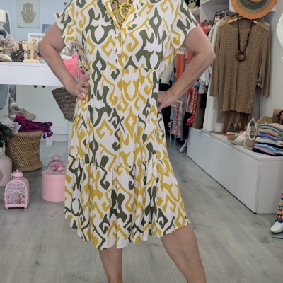 Vestido midi feminino com padrão geométrico amarelo, branco e verde em loja