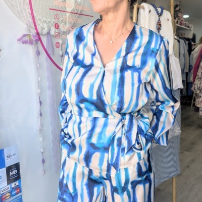 Roupa padrão abstrato azul, branco e bege, blusa e calças largas, mulher dentro de loja de roupa