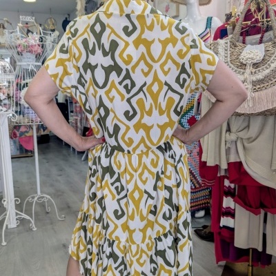 Vestido midi com padrão geométrico amarelo, branco e verde visto de costas