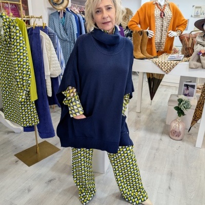 Mulher com roupa de malha azul escura e calças estampadas numa loja de roupas