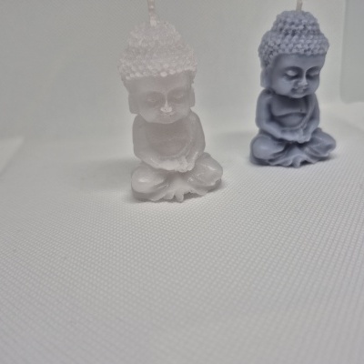 Velas em forma de Buda branco e azul sobre tecido branco