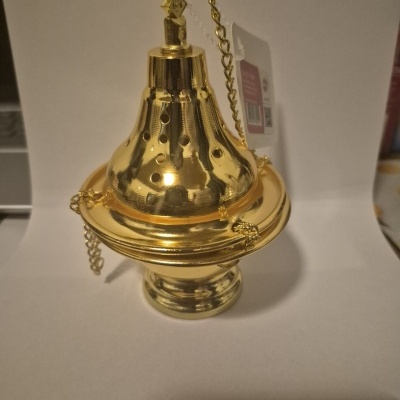 castiçal dourado em fundo branco com etiqueta pendurada