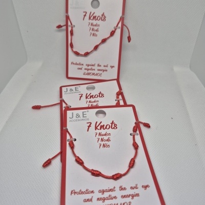 Pulseiras vermelhas com sete nós e cartelas com inscrições em inglês e várias línguas