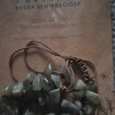 Pulseira semipreciosa de pedra da lua com pedras verdes e cordão castanho em embalagem de cartão