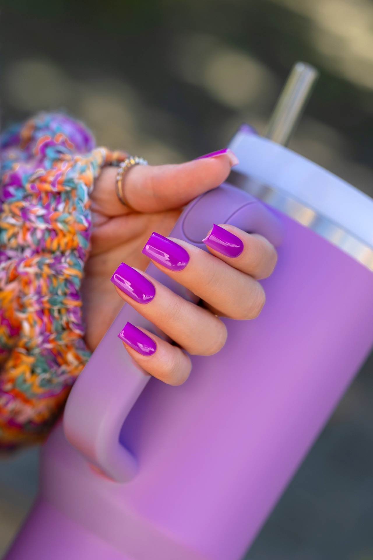 Verniz Gel Hot Pilates Club (Fúcsia‑Violeta Néon) Mão com unhas roxas segurando copo térmico roxo