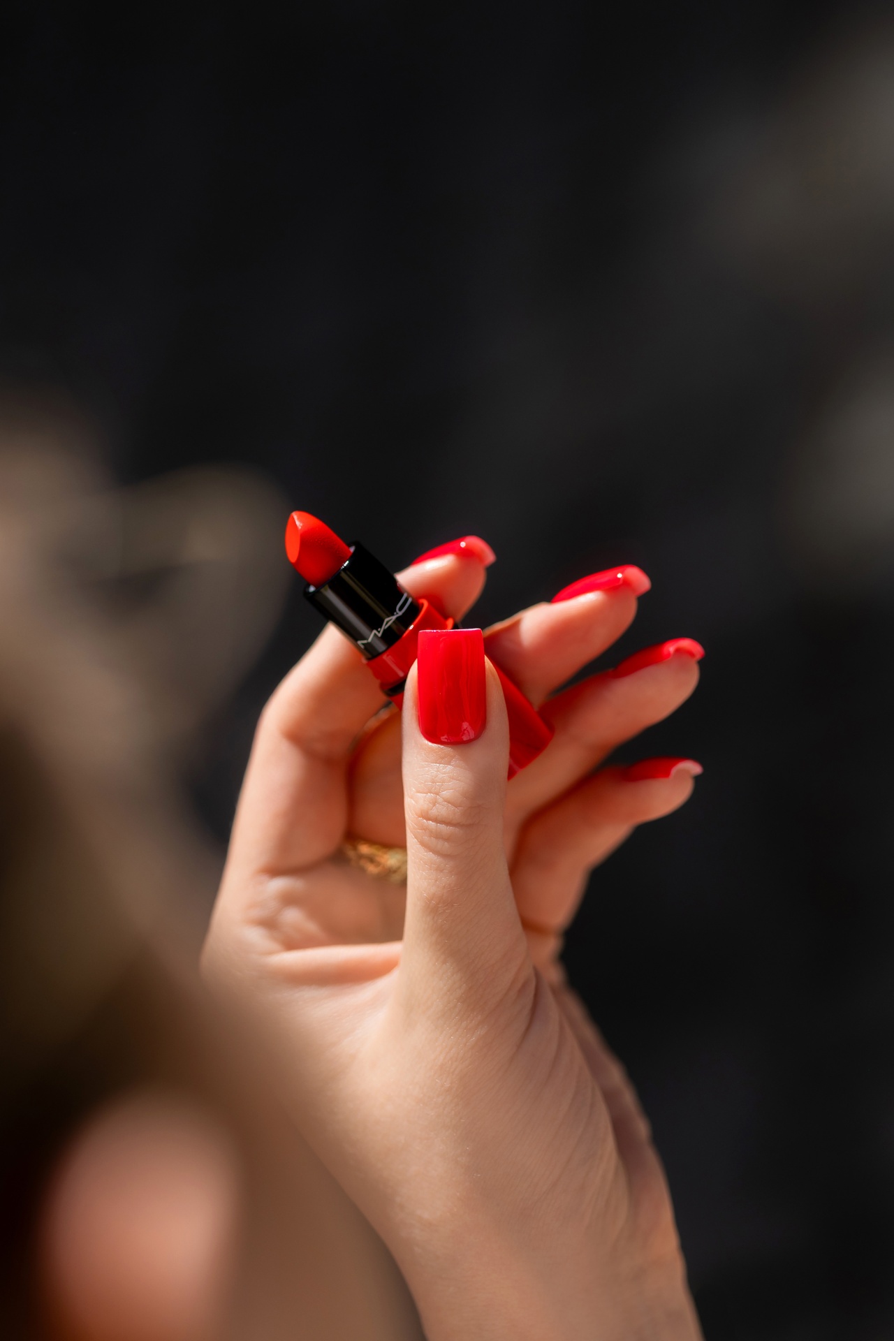 Verniz Gel Red Light Baby (Vermelho Laranja Néon) Batom vermelho MAC numa mão com unhas vermelhas