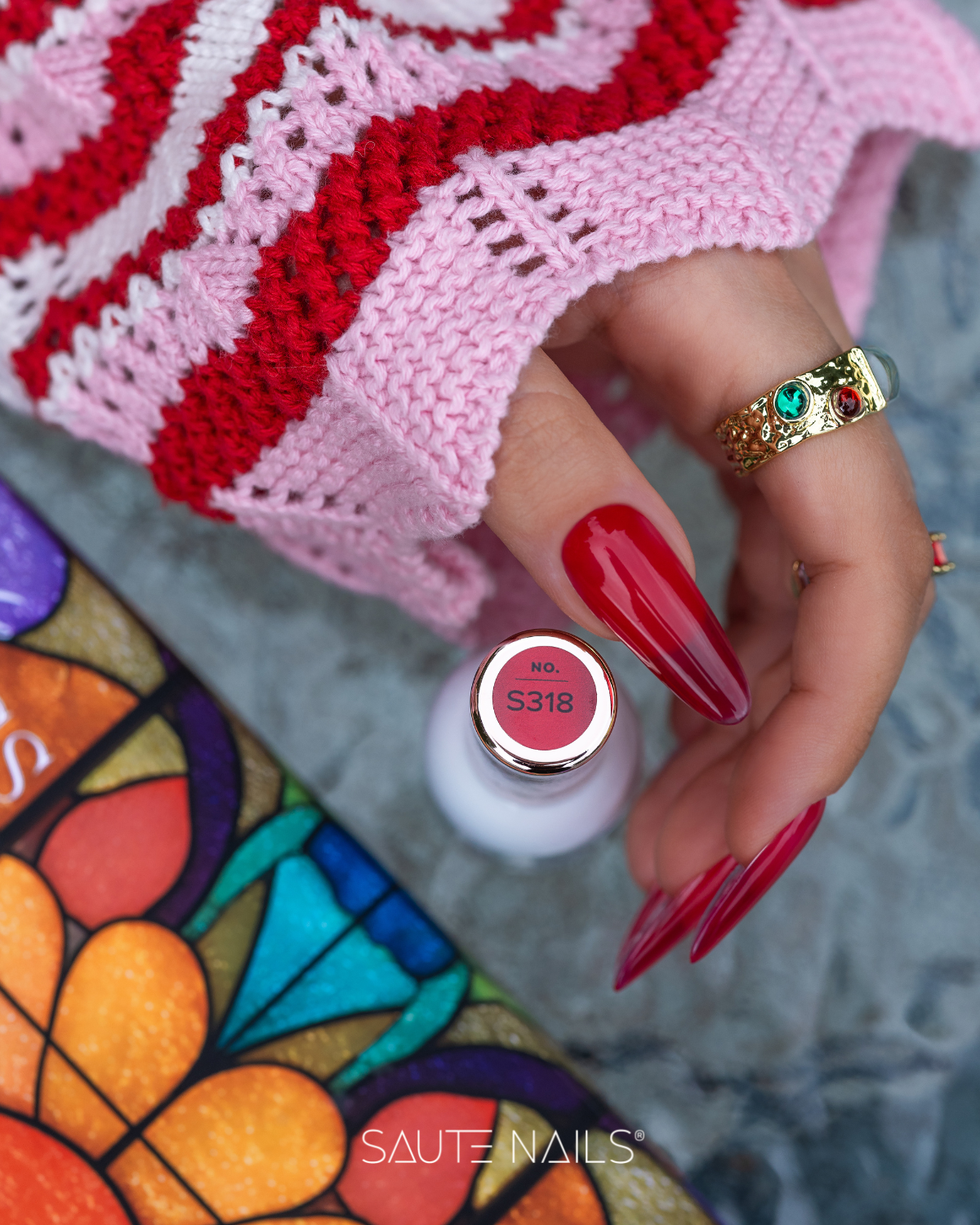 Verniz Gel Saute Nails S318 - Glass Red (Vermelho Semi-transparente) Mão com unhas vermelhas segurando frasco de verniz com etiqueta S318