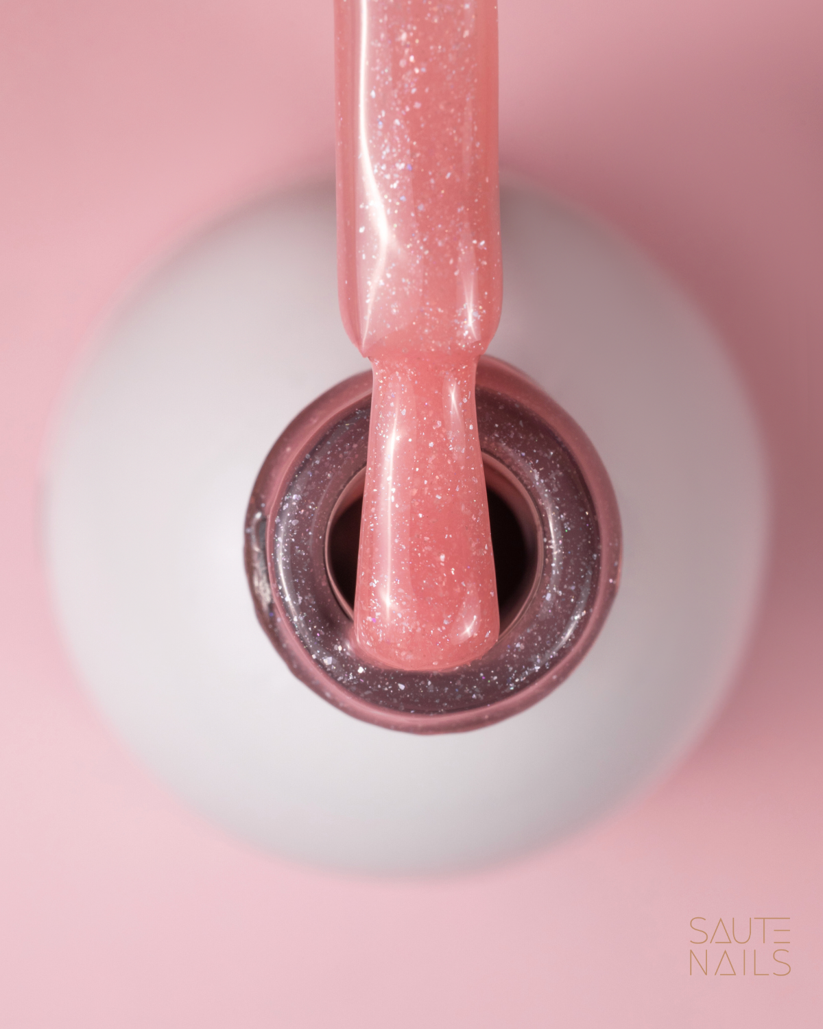 Saute Nails Express Base Sparkling Peachy (Pêssego com Brilho) Frasco aberto de verniz das unhas rosa com brilho e pincel embebido
