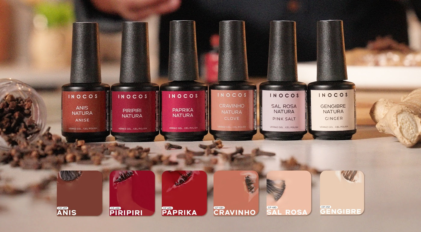 Verniz Gel Inocos – Coleção Natura Lovers - Spice Edition (6 cores) Seis vernizes de unhas em diferentes tons naturais com tampas pretas e nomes visíveis de especiarias, sobre superfície clara com especiarias espalhadas.