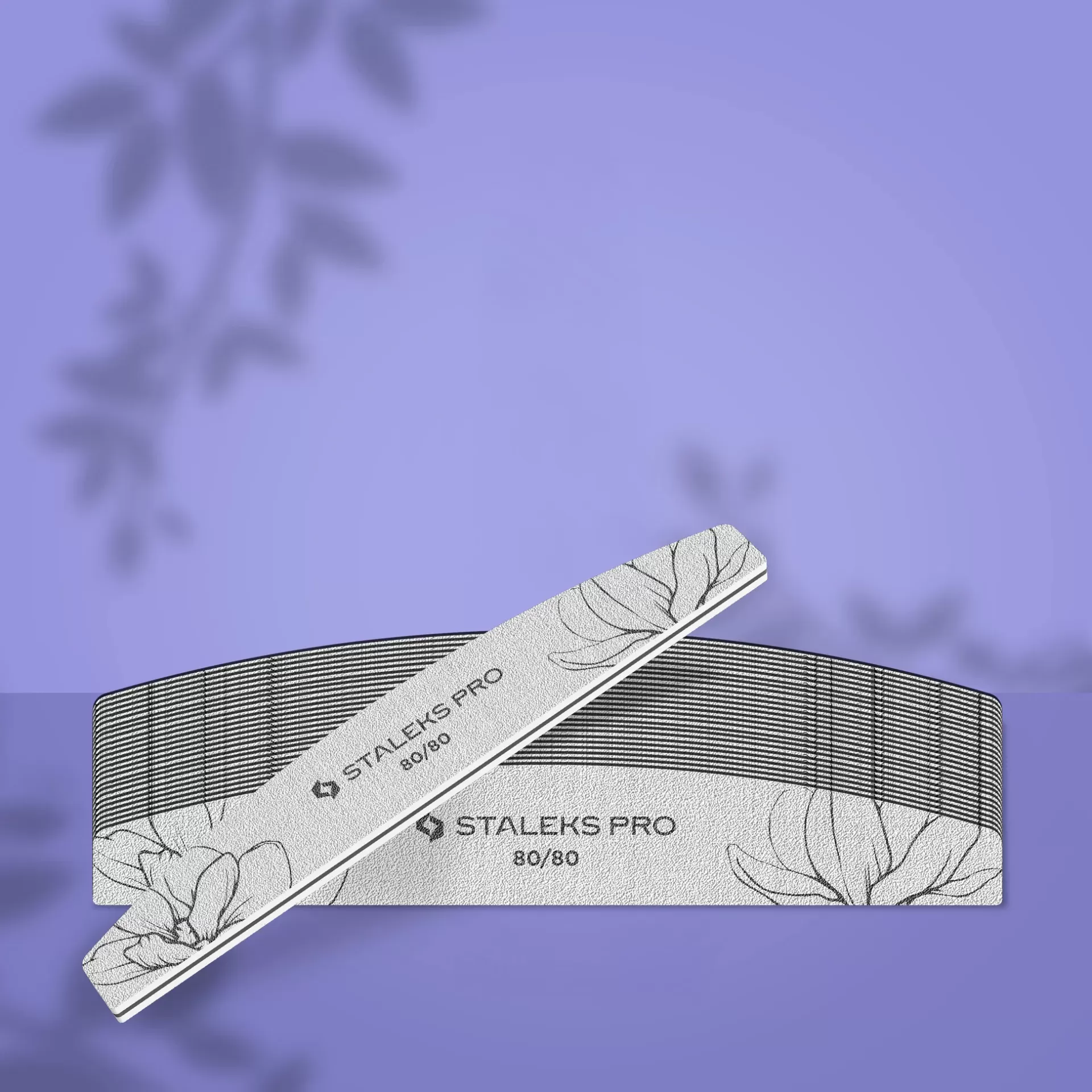 Pack 25 Limas Meia Lua Staleks 80/80 Expert 40 Conjunto de lima de unhas STALEKS PRO 80/80 com padrão de folhas, sobre fundo lilás com sombras de folhas