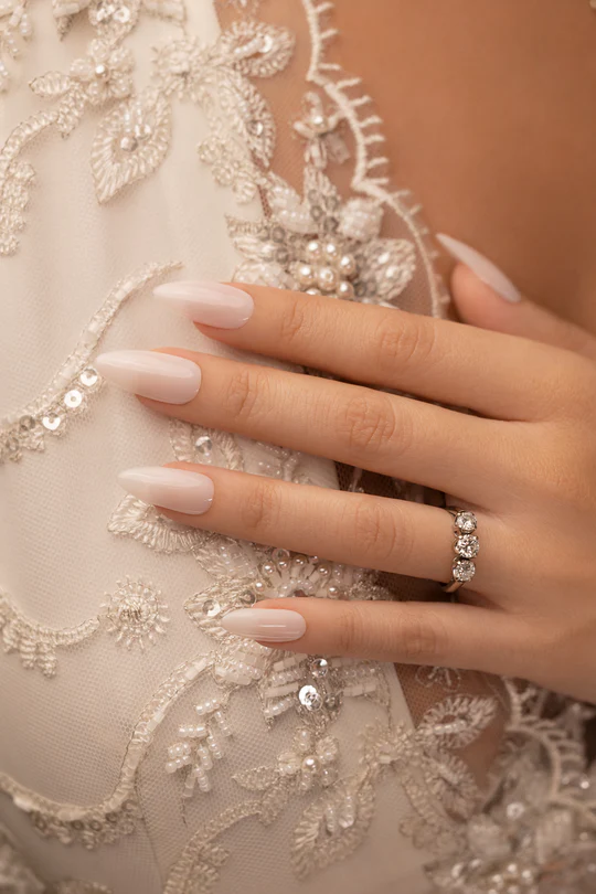 Fusion Color ID4 - Bride - Nude leitoso Mão feminina com unhas brancas e anel sobre tecido branco bordado