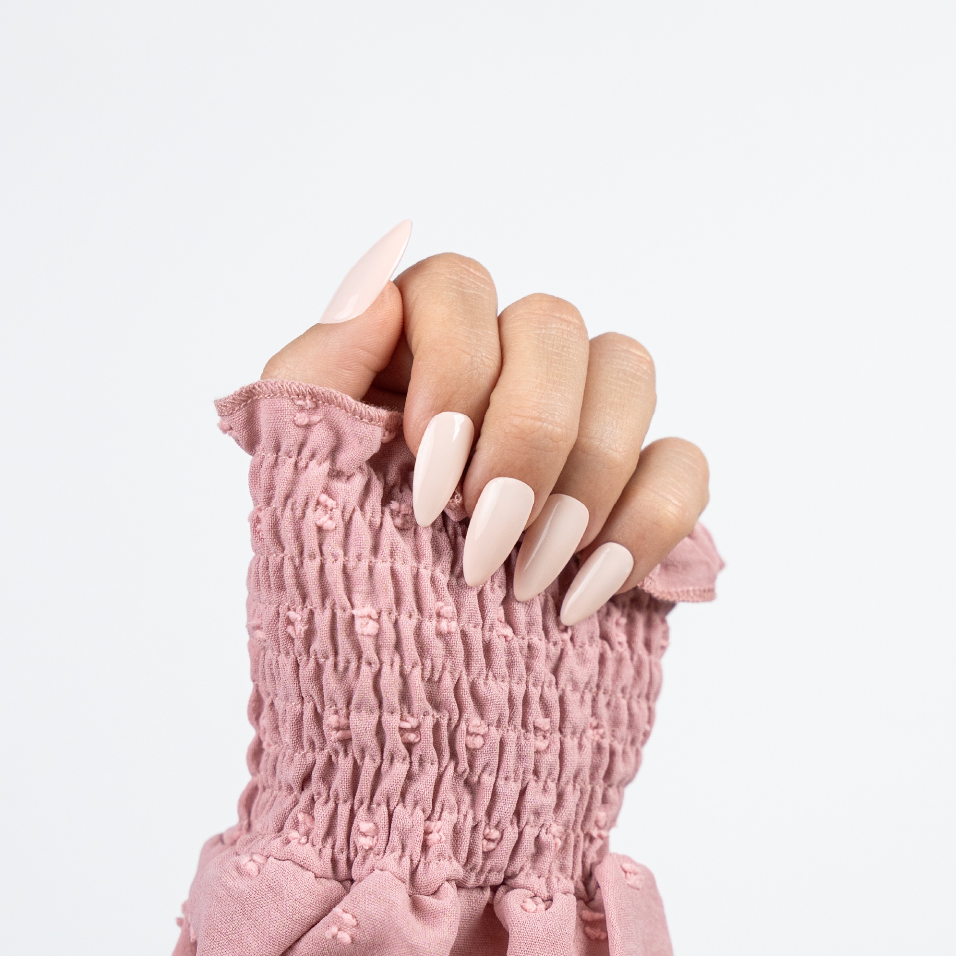 Verniz Gel Inocos 506 - Sonha Mão feminina com unhas postiças cor de rosa claro e manga rosa texturizada