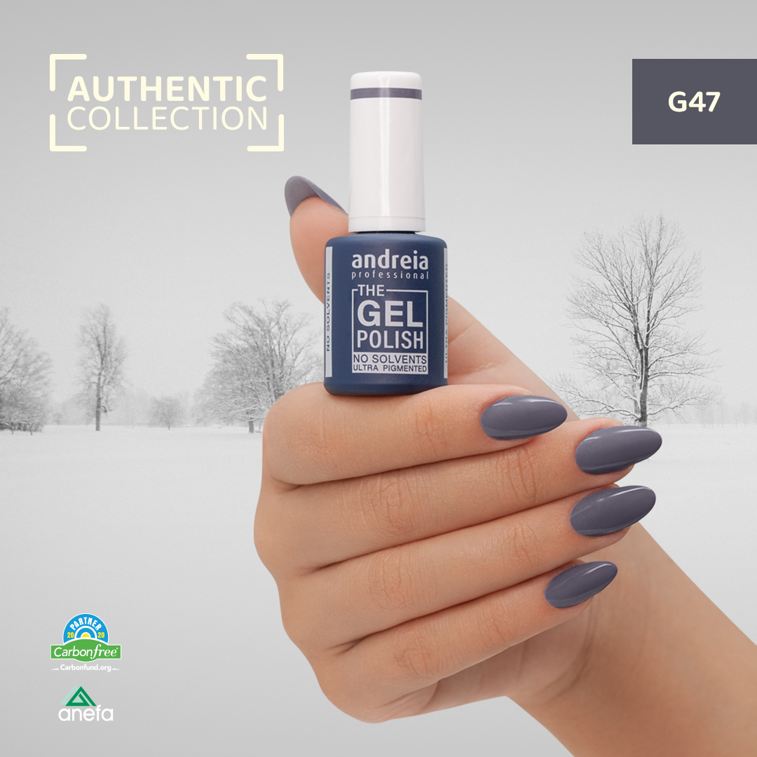 The Gel Polish Andreia G47 – Cold Grey Frasco de verniz gel cinza escuro com unha pintada da mesma cor numa mão feminina