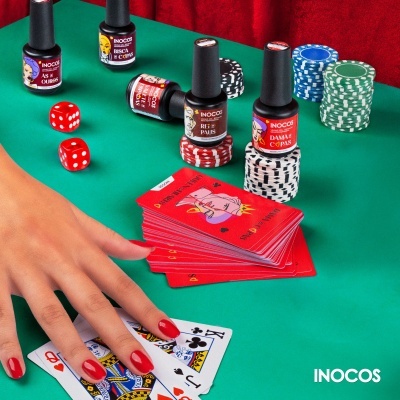 Vernizes INOCOS com fichas de poker, dados e cartas numa mesa verde