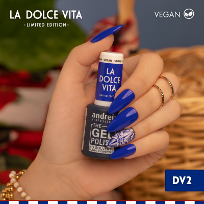 Mão com verniz gel azul La Dolce Vita e unhas decoradas segurando frasco azul