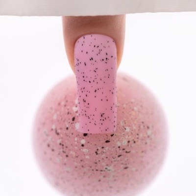 Unha pintada de rosa com partículas pretas e texto SAUTE NAILS
