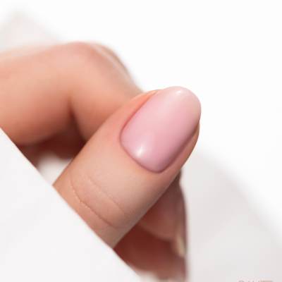 Unha de verniz rosa claro com fundo branco e texto 'SAUTE NAILS'