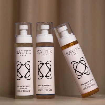 Frascos de spray corporal em gel SAUTE CARE com diferentes fragrâncias e texto nos rótulos sobre fundo bege.