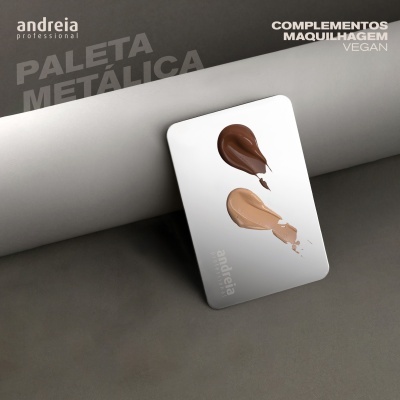 Paleta metálica branca com duas manchas de maquilhagem castanha e bege em superfície cinzenta