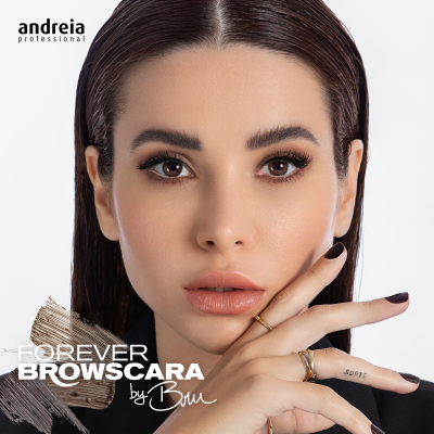 Mulher com maquilhagem e unhas castanhas, anéis dourados, texto promocional em fundo branco