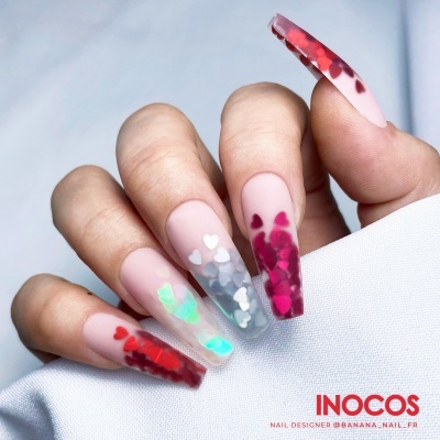 Unhas compridas artificiais nude com corações coloridos e translúcidos