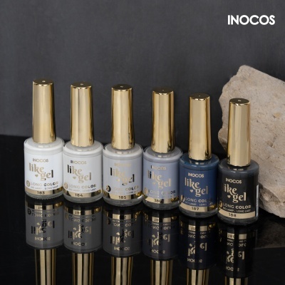 Seis frascos de verniz gel Inocos Like Gel com tampas douradas em várias cores sobre superfície preta refletiva