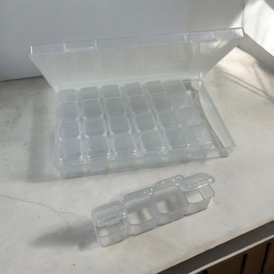 Caixa plástica transparente com tonalidade leitosa e divisórias internas