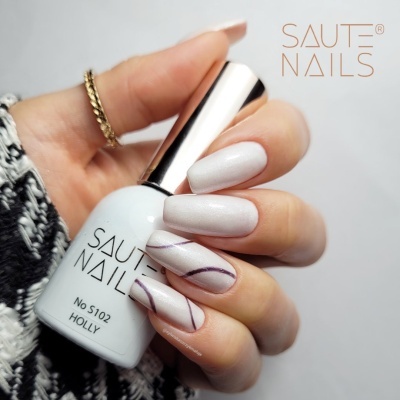 Frasco de verniz SAUTE NAILS e unhas pintadas com verniz branco perolado com desenho roxo