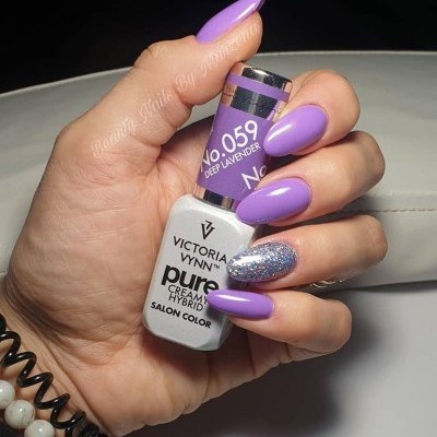 Mão segurando verniz Victoria Vynn roxo lavanda com unha glitter prateado