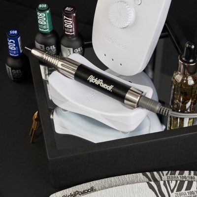 Kit para unhas com máquina elétrica, frascos de gel coloridos, óleo e lixas zebras na bandeja preta