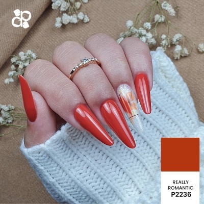 Unhas compridas laranja avermelhadas com unha decorada flores em branco perolado e anel dourado