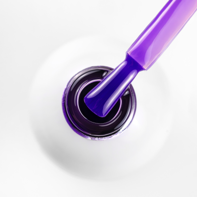 Frasco aberto de verniz roxo para unhas com pincel e fundo branco