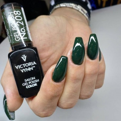 Mão com unhas pintadas de verde escuro segurando frasco de verniz gel VICTORIA VYNN n.º 208