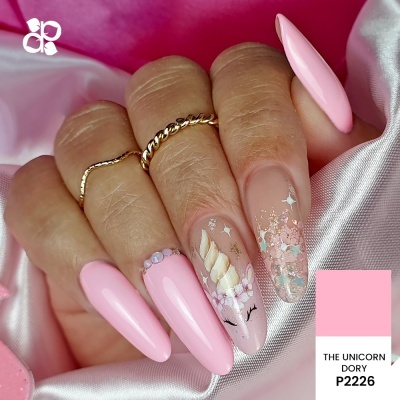 Unhas longas triangulares rosa claro com decoração de unicórnio e glitter sobre tecido rosa brilho.