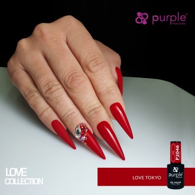 Mão com unhas vermelhas longas e pontiagudas decoradas com pedras brilhantes e frasco de verniz gel vermelho