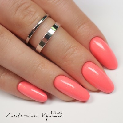 Mão feminina com unhas rosa coral e dois anéis prateados