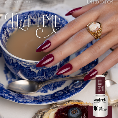 Mão com unhas vinho escuro ao lado de chávena e prato azul e branco e biscoito com creme e doce