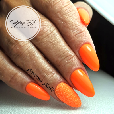 Unhas com verniz laranja fluorescente e uma unha texturizada granulada