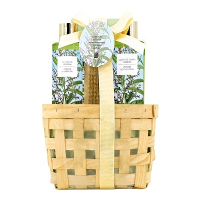 Conjunto de produtos de cuidados pessoais em cesto com esponja e três frascos verdes decorados com flores