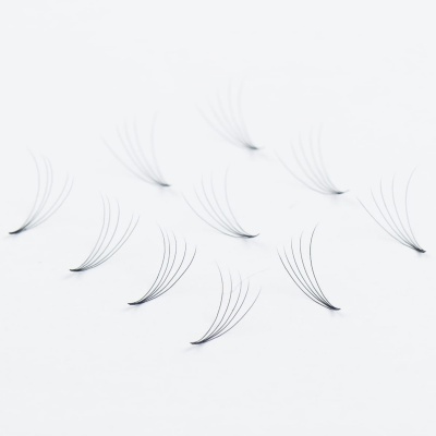 Extensões de cílios individuais finas negras em leques sobre fundo branco