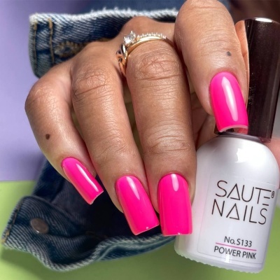 Unhas pintadas de rosa forte com frasco de verniz branco SAUTE NAILS POWER PINK