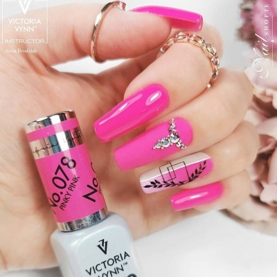 Unhas com esmalte rosa brilhante Victoria Vynn e decoração com pedras em fundo desfocado.