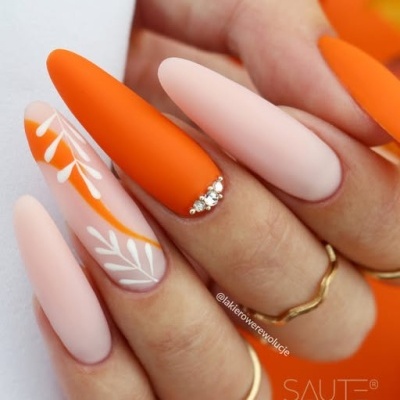 Unhas compridas mate com cores laranja e rosa, flores brancas e cristais