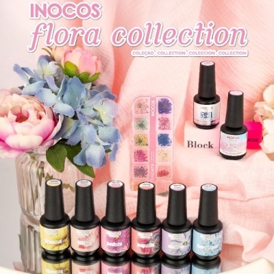 Vários frascos de verniz de unhas Inocos flora collection com blocos e acessórios em fundo com pano rosa e flores