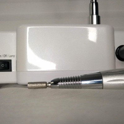 Dispositivo elétrico branco com interruptor e peça metálica cilíndrica