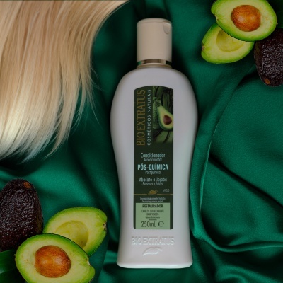 Condicionador Bioextratus Pós-química de 250ml com abacate e cabelo loiro sobre tecido verde