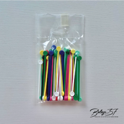 Sacos transparentes com varas plásticas coloridas sobre superfície branca