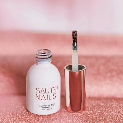 Frasco de verniz de unhas SAUTE NAILS aberto com aplicador, em fundo rosa brilhante.